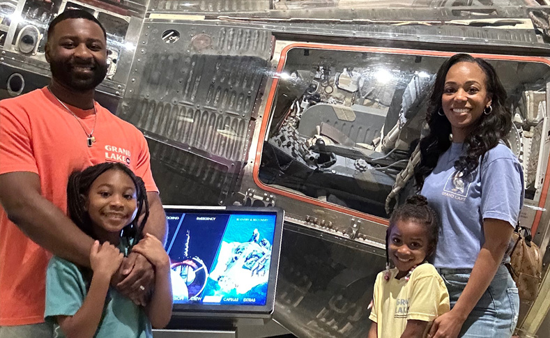 Family standing in front of a space capsule at the Armstrong Air and Space Museum in Wapakoneta Ohio