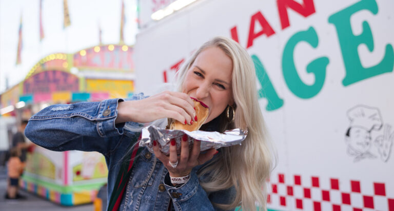 Girl eating a hot dog at a festival in Ohios Grand Lake Region